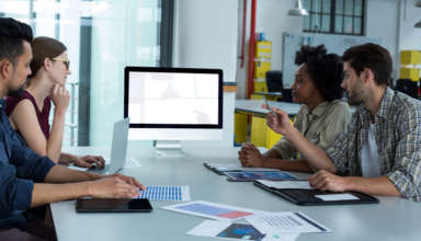 Equipe em reunião em volta de um computador